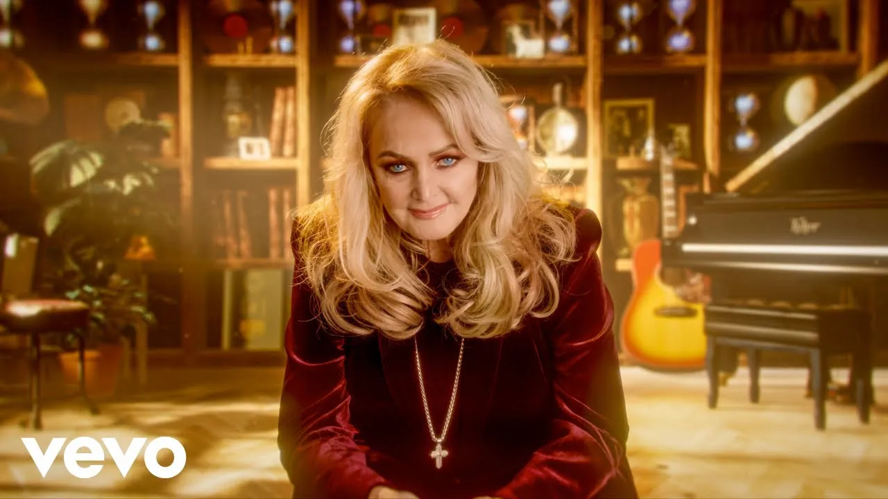 Bonnie Tyler en una imagen de su canal oficial, sentada frente a una biblioteca y un piano